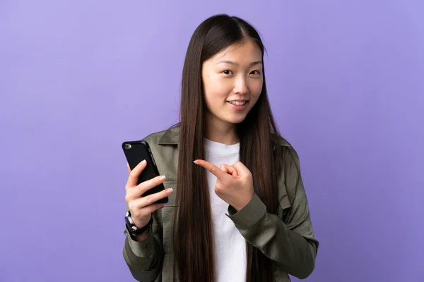 Young Chinese Girl Using Mobile Phone Isolated Purple Background Pointing — Stock Photo, Image