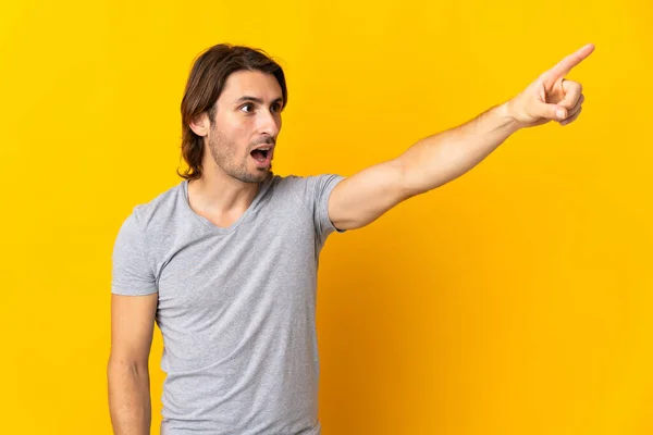 Joven Hombre Guapo Aislado Sobre Fondo Amarillo Apuntando Lejos — Foto de Stock