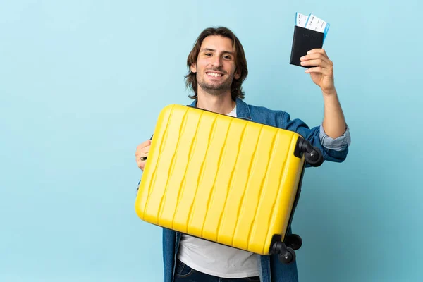 Jonge Knappe Man Geïsoleerd Blauwe Achtergrond Vakantie Met Koffer Paspoort — Stockfoto