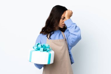 Pasta şefi elinde büyük bir pasta ile izole edilmiş beyaz arka plan üzerinde baş ağrısı ile