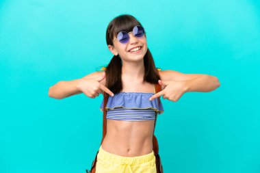 Küçük beyaz çocuk kumsala gidiyor mavi arka planda tek başına gururlu ve kendinden memnun.