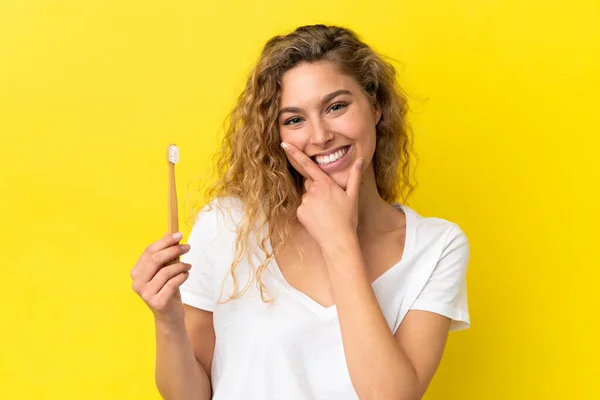 Młoda Biała Kobieta Trzyma Szczotkujące Zęby Odizolowane Żółtym Tle Szczęśliwa — Zdjęcie stockowe