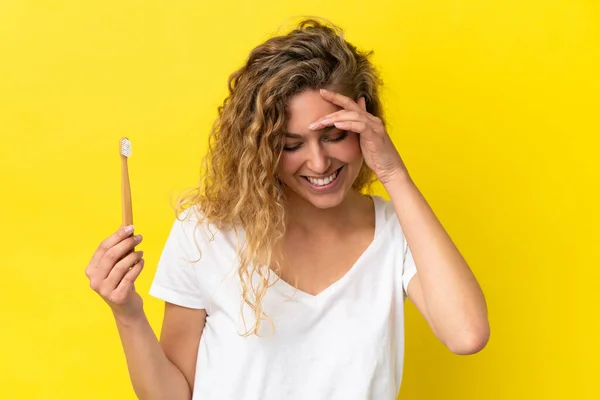 Młoda Biała Kobieta Trzymająca Szczotkujące Zęby Odizolowane Żółtym Tle Śmiejąc — Zdjęcie stockowe
