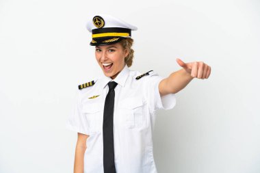 Uçaktaki sarışın kadın pilot beyaz arka planda izole edilmiş bir şekilde baş parmak hareketi yapıyor.