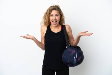 Spor çantalı genç bir kadın beyaz arka planda izole edilmiş, şok olmuş bir yüz ifadesi var.