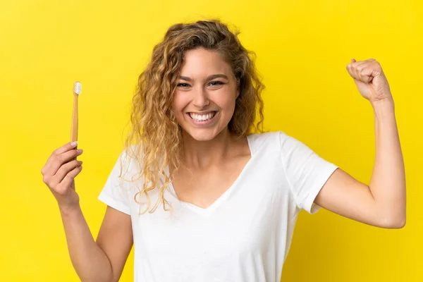 Młoda Biała Kobieta Trzymająca Szczotkujące Zęby Odizolowane Żółtym Tle Wykonująca — Zdjęcie stockowe
