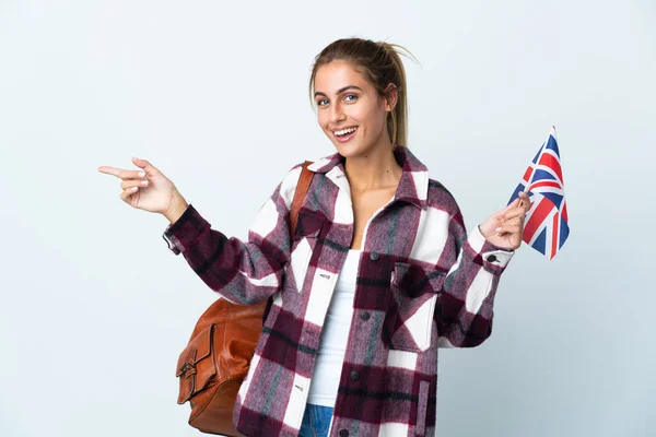 年轻女子拿着一面英国国旗 被白色背景隔离 手指指向侧面 — 图库照片