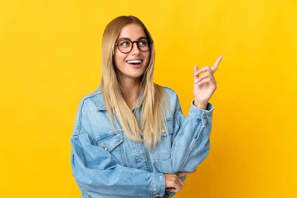 Jonge Blonde Vrouw Geïsoleerd Gele Achtergrond Wijzend Een Geweldig Idee — Stockfoto