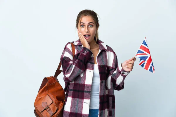年轻女子举着一面英国国旗 背景为白色 脸上带着惊讶和震惊的表情 — 图库照片