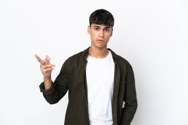 Soyutlanmış beyaz arka planı olan genç bir adam şüpheli hareketler yapıyor.