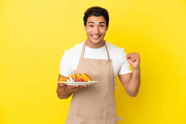 Cameriere Ristorante Che Tiene Cialde Sfondo Giallo Isolato Celebrando Una — Foto Stock