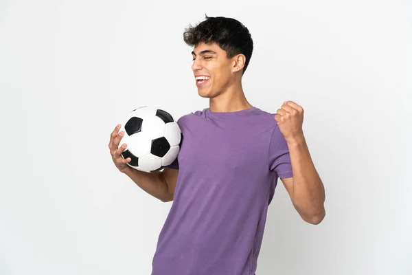 Junger Mann Vor Isoliertem Weißen Hintergrund Mit Fußballball Feiert Einen — Stockfoto