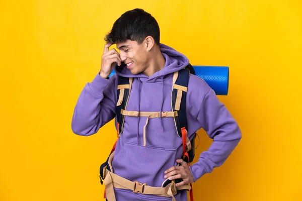 Junger Bergsteiger Mit Großem Rucksack Vor Einsamem Gelben Hintergrund Lacht — Stockfoto