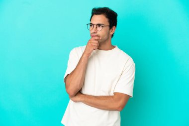 Kafkasyalı yakışıklı bir adam, soyutlanmış mavi bir geçmişi var. Şüpheleri var ve kafası karışmış bir yüz ifadesi var.