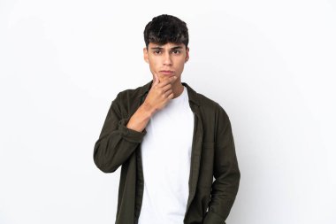 Soyutlanmış beyaz bir arka plan düşünen genç adam.