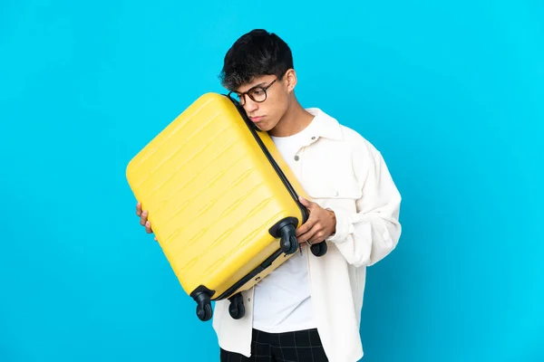 Joven Sobre Fondo Azul Aislado Vacaciones Con Maleta Viaje Infeliz — Foto de Stock