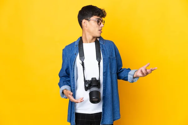 Genç Fotoğrafçı Yalıtılmış Sarı Arka Planda Sürpriz Bir Ifadeyle Yan — Stok fotoğraf