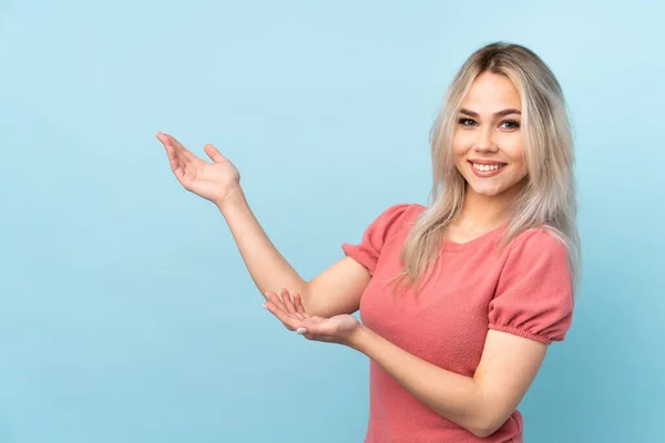 Tonårstjej Över Isolerad Blå Bakgrund Sträcker Händerna Sidan För Inbjudande — Stockfoto