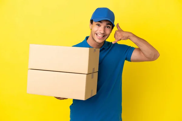 Delivery Man Isolated Yellow Wall Making Phone Gesture Call Back — Stock Photo, Image