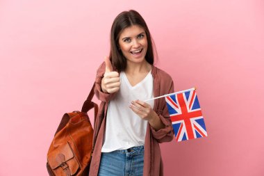 Kafkasyalı genç bir kadın pembe arka planda izole edilmiş bir Birleşik Krallık bayrağı tutuyor. Çünkü iyi bir şey oldu.