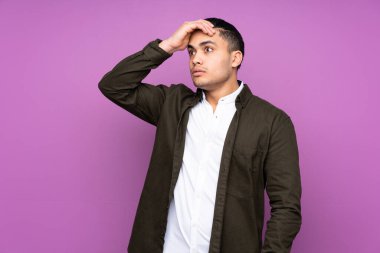 Asyalı yakışıklı adam mavi arka planda izole edilmiş. Yan tarafa bakarken sürpriz jest yapıyor.