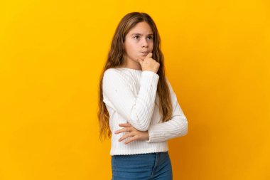 İzole edilmiş sarı arka planda kuşkuları ve düşünceleri olan bir çocuk