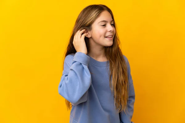 Kind Geïsoleerde Gele Achtergrond Luisteren Naar Iets Door Hand Het — Stockfoto