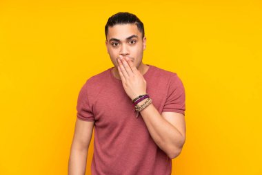 Asyalı yakışıklı adam sarı arka planda izole edilmiş cep telefonuyla biriyle sohbet ediyor.