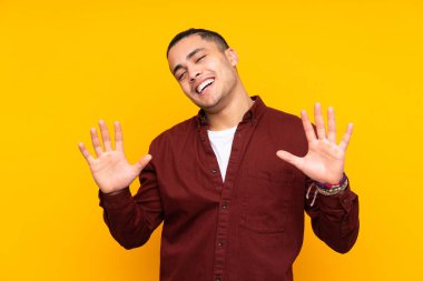 Asyalı yakışıklı adam sarı arka planda izole edilmiş, yorgun ve hasta bir ifadeyle.