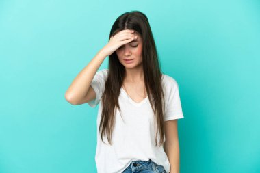 Kafkasyalı genç bir kadın mavi arka planda izole edilmiş, baş ağrısı var.