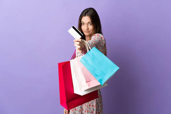 아일랜드의한 여자는 쇼핑백 과신용 카드를 보라색 배경에 고립되어 있었다 — 스톡 사진