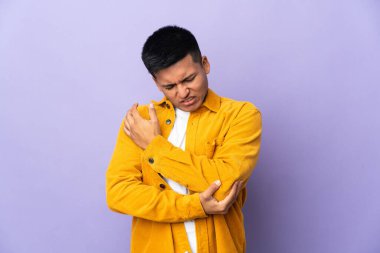 Young Ecuadorian man isolated on purple background with pain in elbow