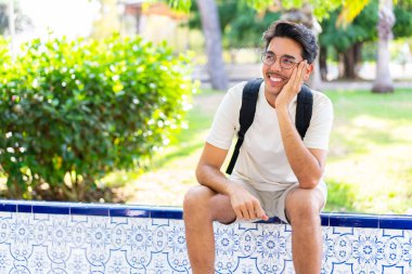 Açık havada mutlu bir ifadeyle genç bir öğrenci.