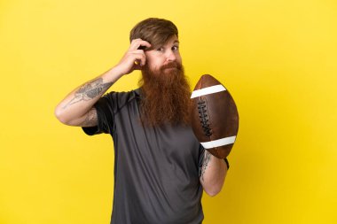 Kızıl saçlı beyaz adam sarı arka planda ragbi oynuyor. 