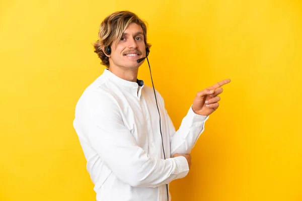 Telefon Pazarlamacısı Sarı Arka Planda Izole Edilmiş Bir Kulaklıkla Çalışıyor — Stok fotoğraf