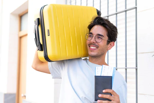 若いです白人男性で休暇で屋外でスーツケースとパスポート — ストック写真