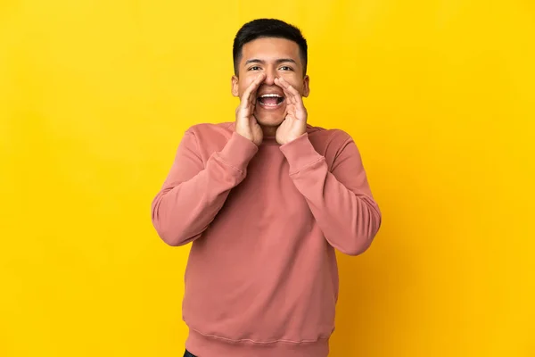 Young Ecuadorian Man Isolated Yellow Background Shouting Announcing Something — Stok fotoğraf