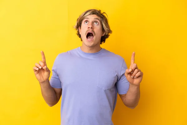 Handsome Blonde Man Isolated Yellow Background Surprised Pointing — Φωτογραφία Αρχείου