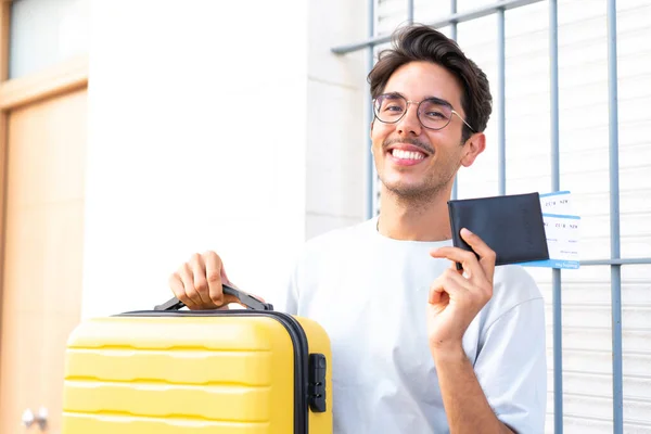 若いです白人男性で休暇で屋外でスーツケースとパスポート — ストック写真