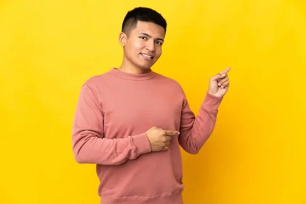 Young Ecuadorian Man Isolated Yellow Background Pointing Finger Side — Zdjęcie stockowe