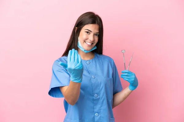 Mulher Dentista Segurando Ferramentas Isoladas Fundo Rosa Convidando Para Vir — Fotografia de Stock