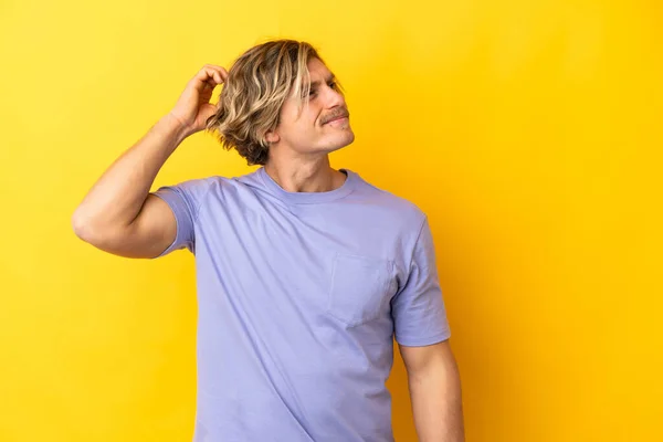 Handsome Blonde Man Isolated Yellow Background Having Doubts While Scratching — Foto Stock