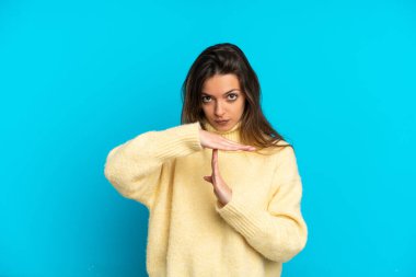 Genç beyaz kadın, mavi arka planda izole edilmiş.
