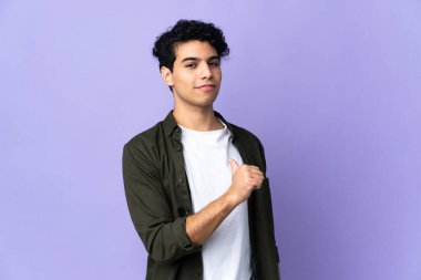 Genç Venezuelalı adam mor arka planda soyutlanmış gururlu ve kendini beğenmiş