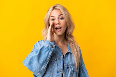 Sarı arka planda izole edilmiş genç bir Rus kadın ağzı açık bağırıyor.