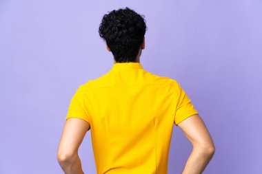 Genç Venezuelalı adam arka planda mor arka planda izole edilmiş.