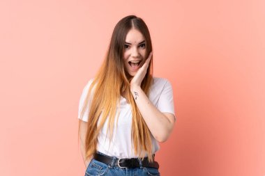 Pembe arka planda izole edilmiş beyaz bir kadın. Şaşırmış ve şok olmuş bir yüz ifadesi var.