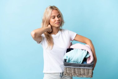 Elinde elbise sepeti olan genç bir Rus kadın mavi arka planda izole edilmiş, boyun ağrısı olan.