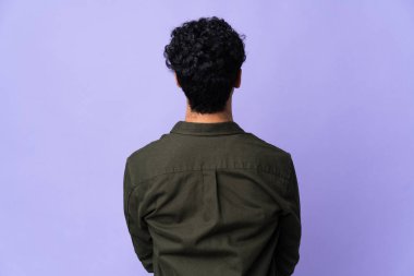 Genç Venezuelalı adam arka planda mor arka planda izole edilmiş.