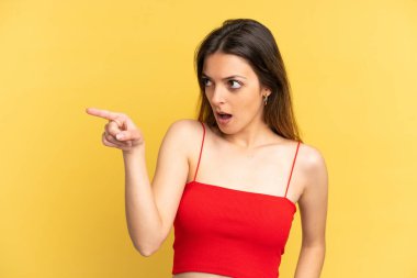 Sarı arka planda izole edilmiş genç beyaz kadın...